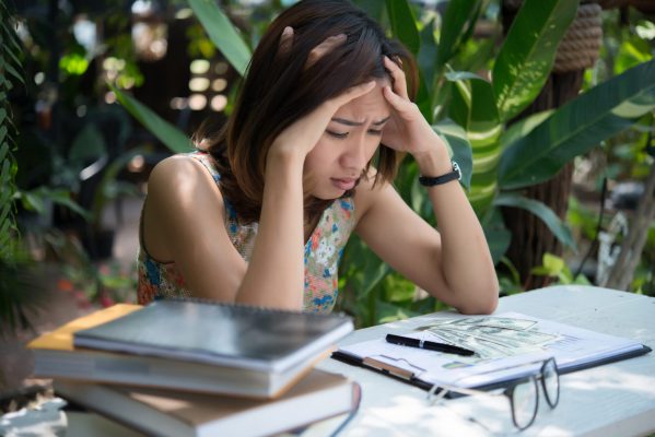 Women with stress hands on head while thinking with new project at workplace.